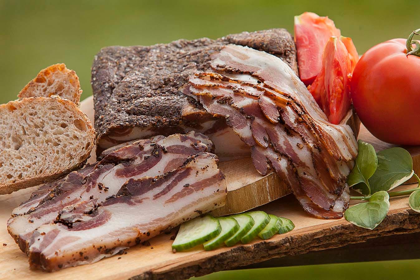 Charcuterie, bread, and tomatoes on a wooden table