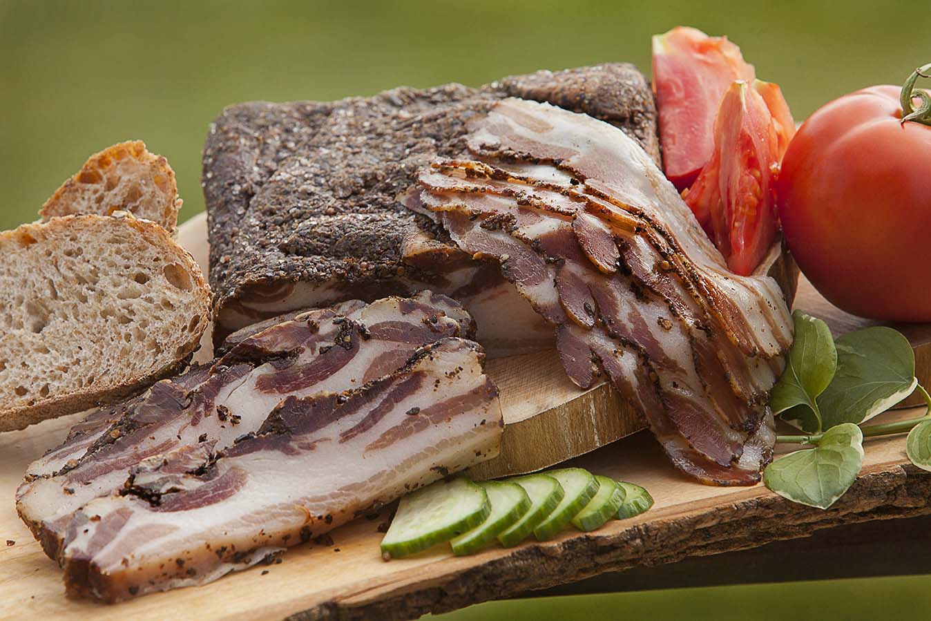 Charcuterie, bread, and tomatoes on a wooden table
