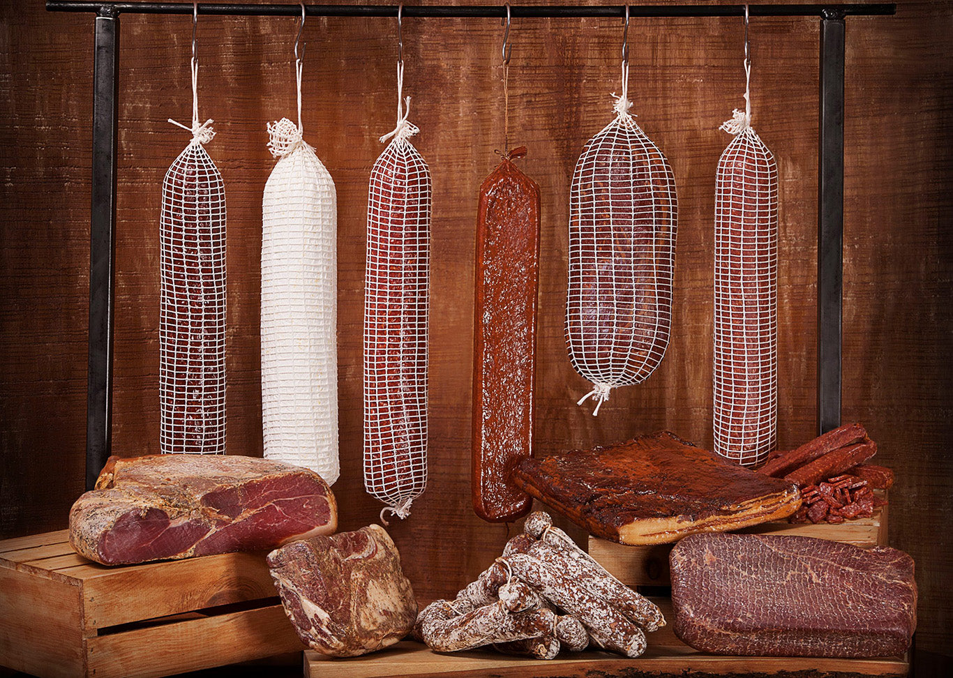 Assortment of Josef’s Artisan cured meats and sausages on rustic wooden crates