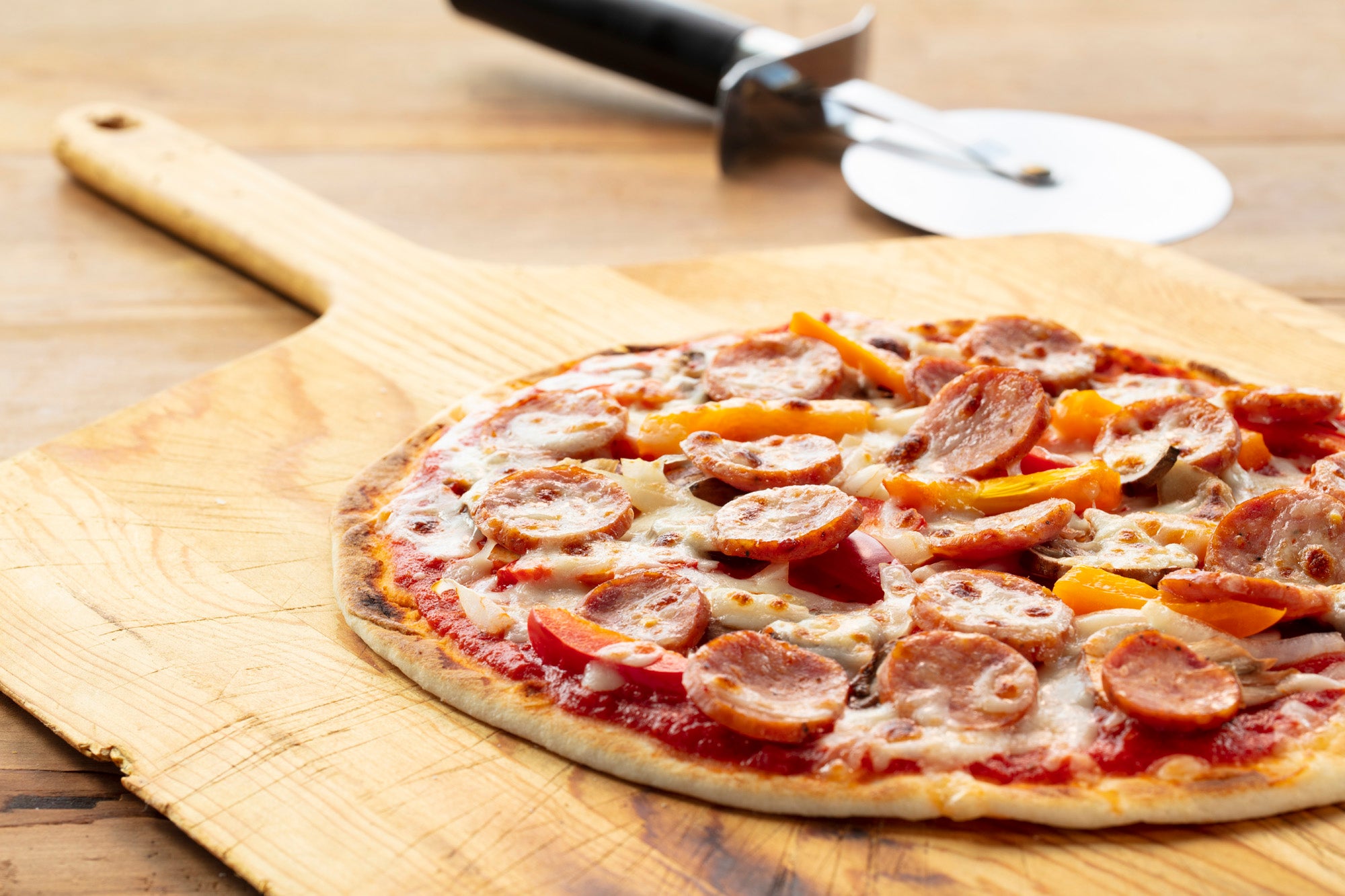 Andouille sausage pizza on a wooden board